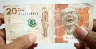 Detalle de las medidas de seguridad del billete de $20.000 pesos colombianos, incluyendo marcas de agua, cintas de seguridad y cambios de color.