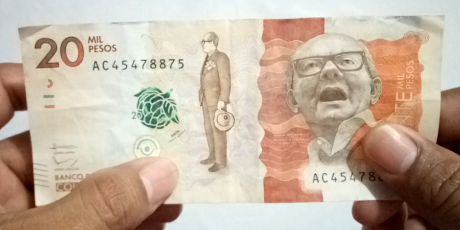 Detalle de las medidas de seguridad del billete de $20.000 pesos colombianos, incluyendo marcas de agua, cintas de seguridad y cambios de color.